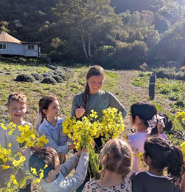 Bambini si prendono cura di una pianta in un giardino, metafora dell'educazione naturale e dello sviluppo del potenziale umano come nell'agricoltura biologica