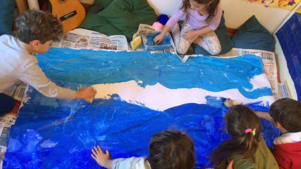 Bambini di scuola primaria che dipingono un mare blu per ritrovare la calma collettiva